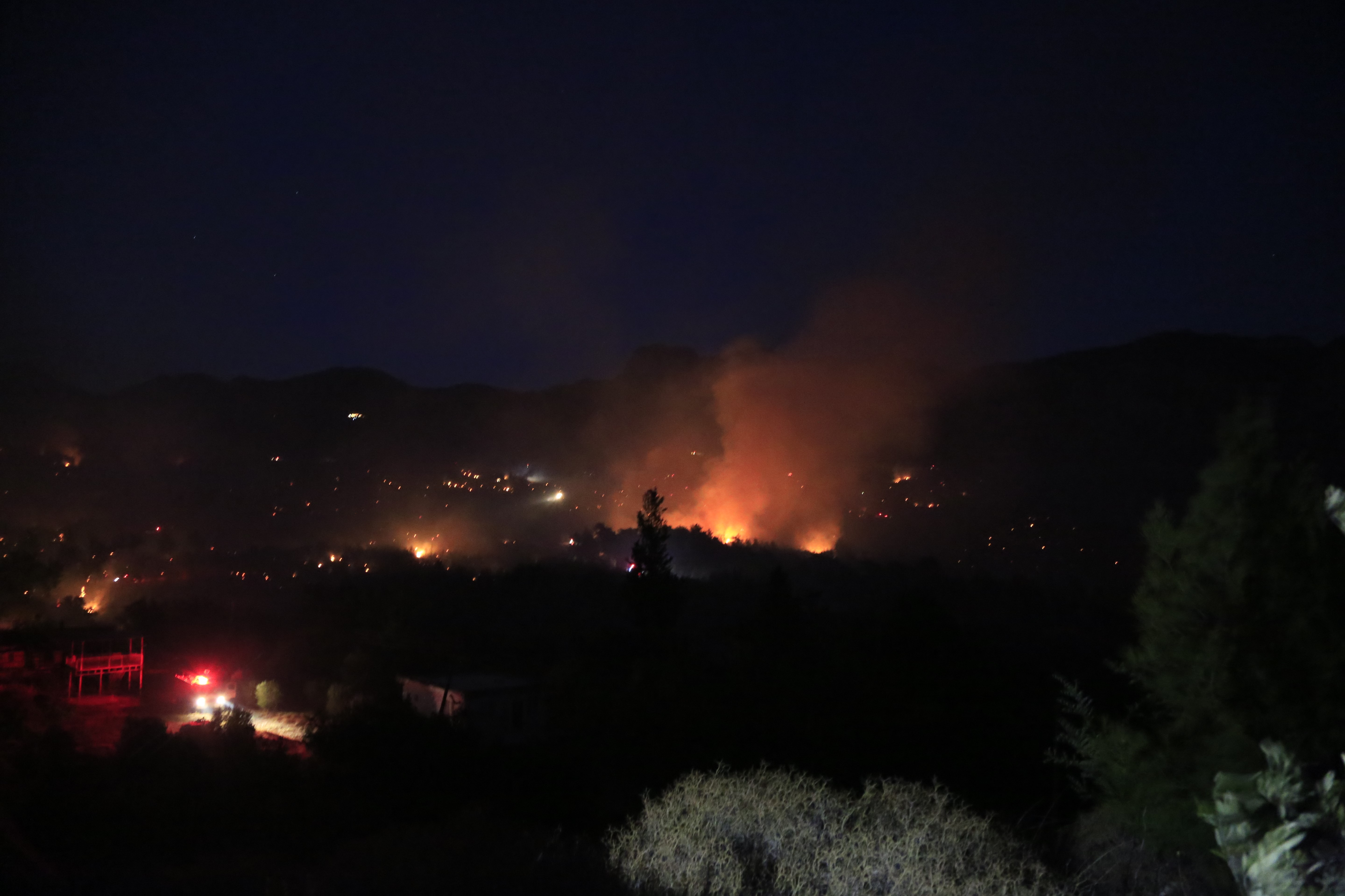 Antalya'nın Serik ilçesinde çıkan yangın rüzgarın etkisiyle yayılıyor