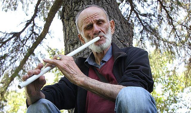 Kesik parmaklarıyla süpürge sapından yaptığı neyi çalıyor