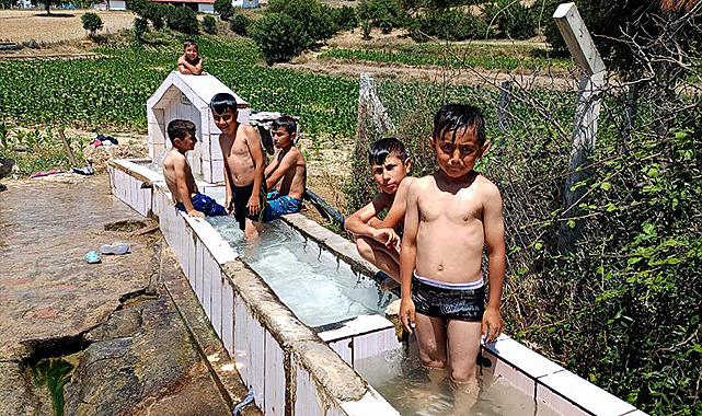 Sıcaktan bunalan çocuklar yalakta serinledi