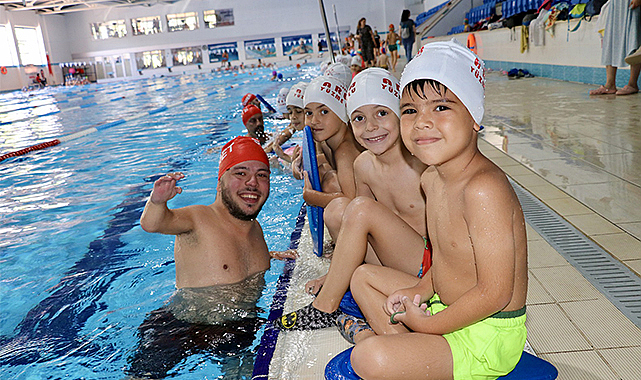Ortopedik engelli antrenör çocuklara yüzme öğretiyor
