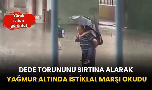 Dede torununu sırtına alarak yağmur altında İstiklal Marşı okudu