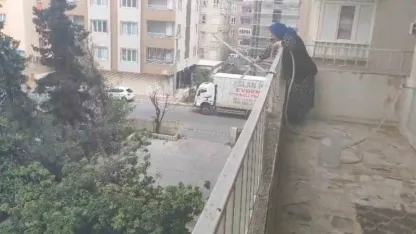 Alev alan aracı yaşlı kadın balkondan söndürmeye çalıştı