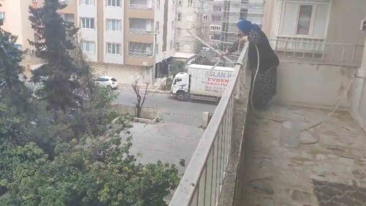 Alev alan aracı yaşlı kadın balkondan söndürmeye çalıştı